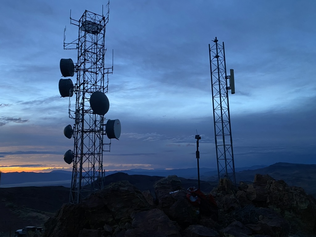 Microwave towers on Toulon Peak silhouetted against the last light on the horizon