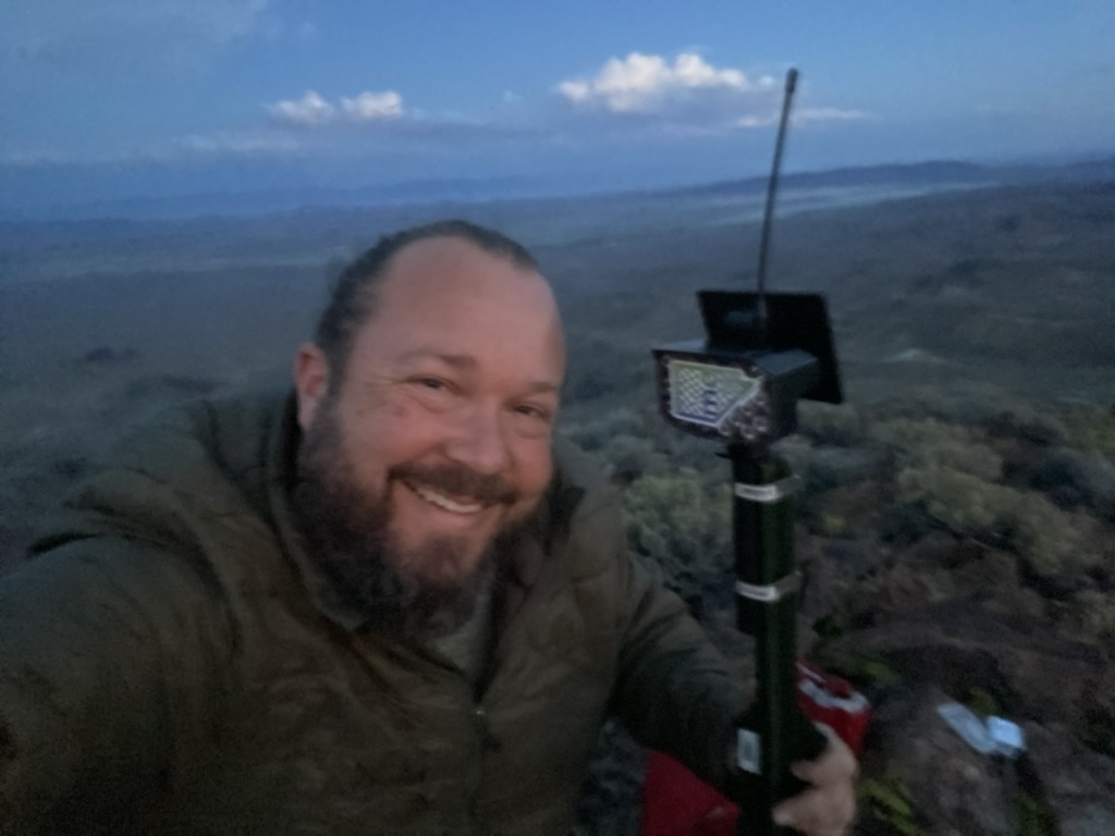 MeshCore node on a pole at Toulon Peak with the mc logo visible at twilight