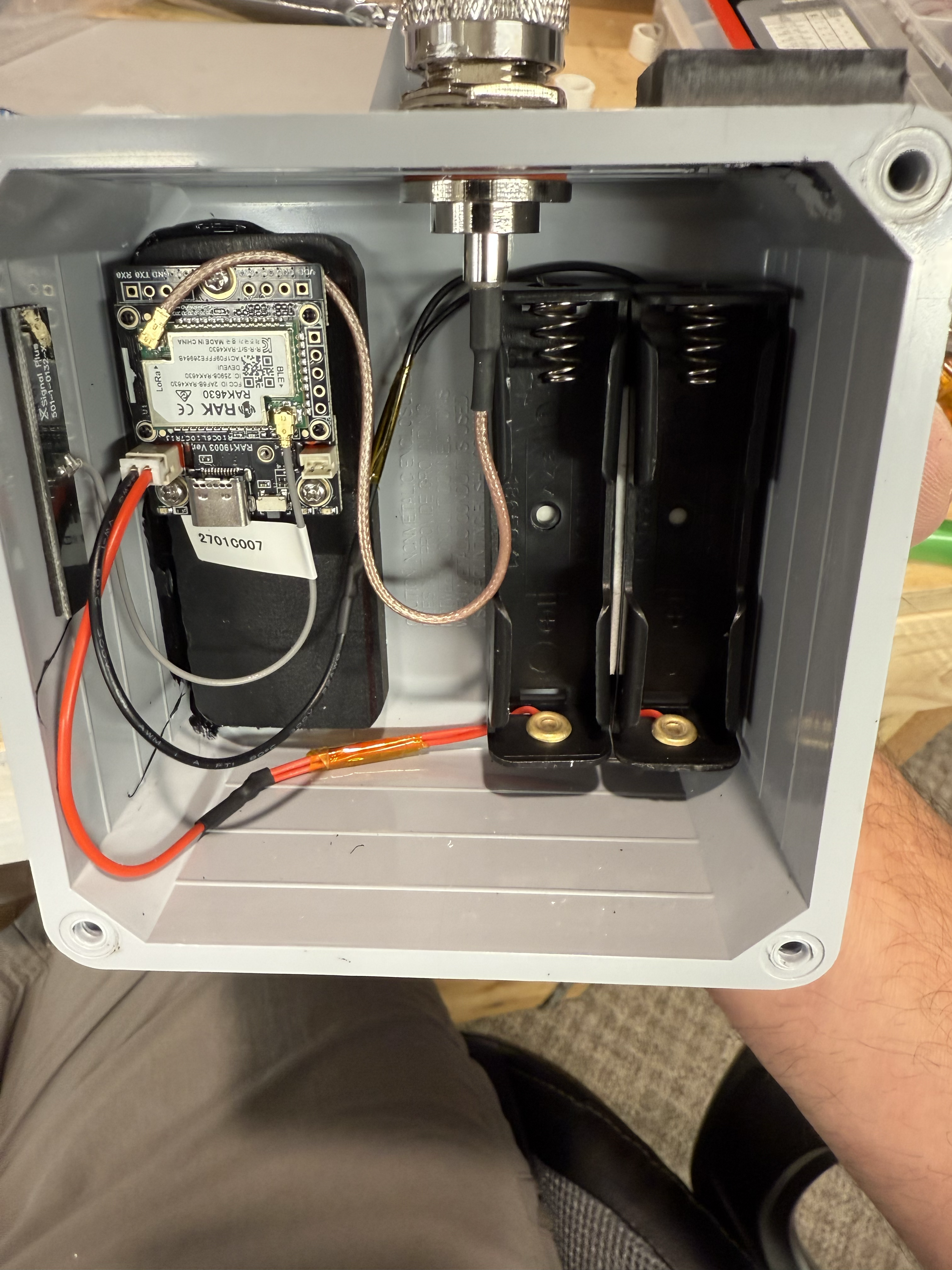 Inside a gray sealed enclosure: RAK4630 module, dual 18650 holder, and bulkhead antenna connector