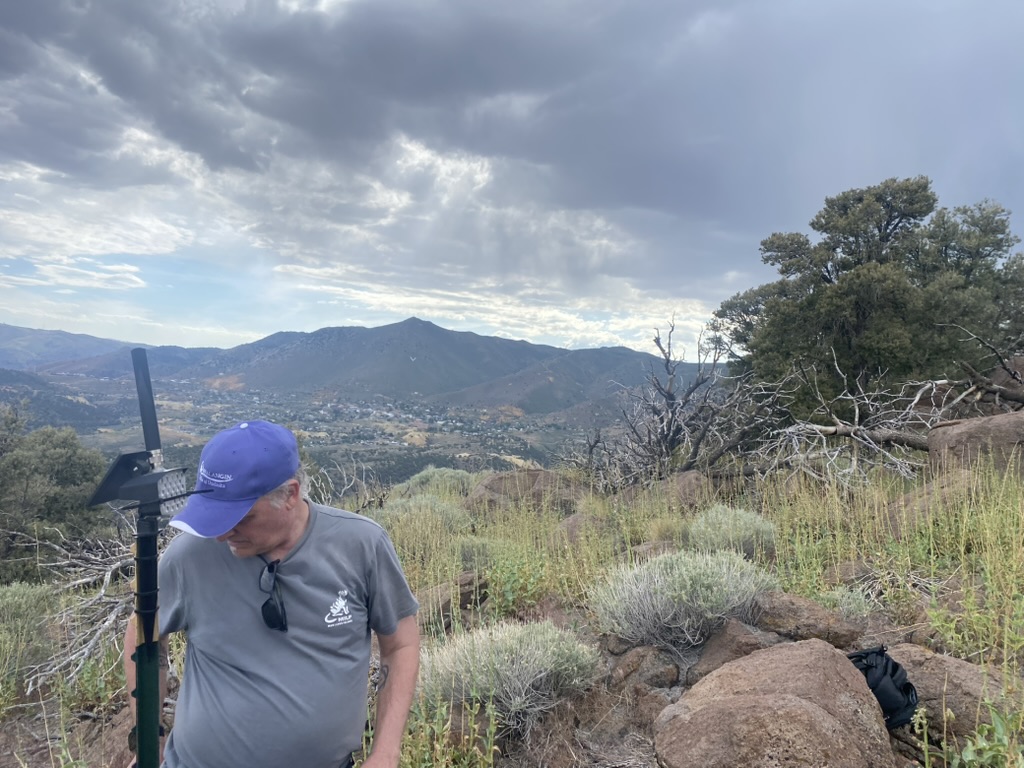 Mesh node on a T-post overlooking Virginia City under storm clouds breaking over the valley