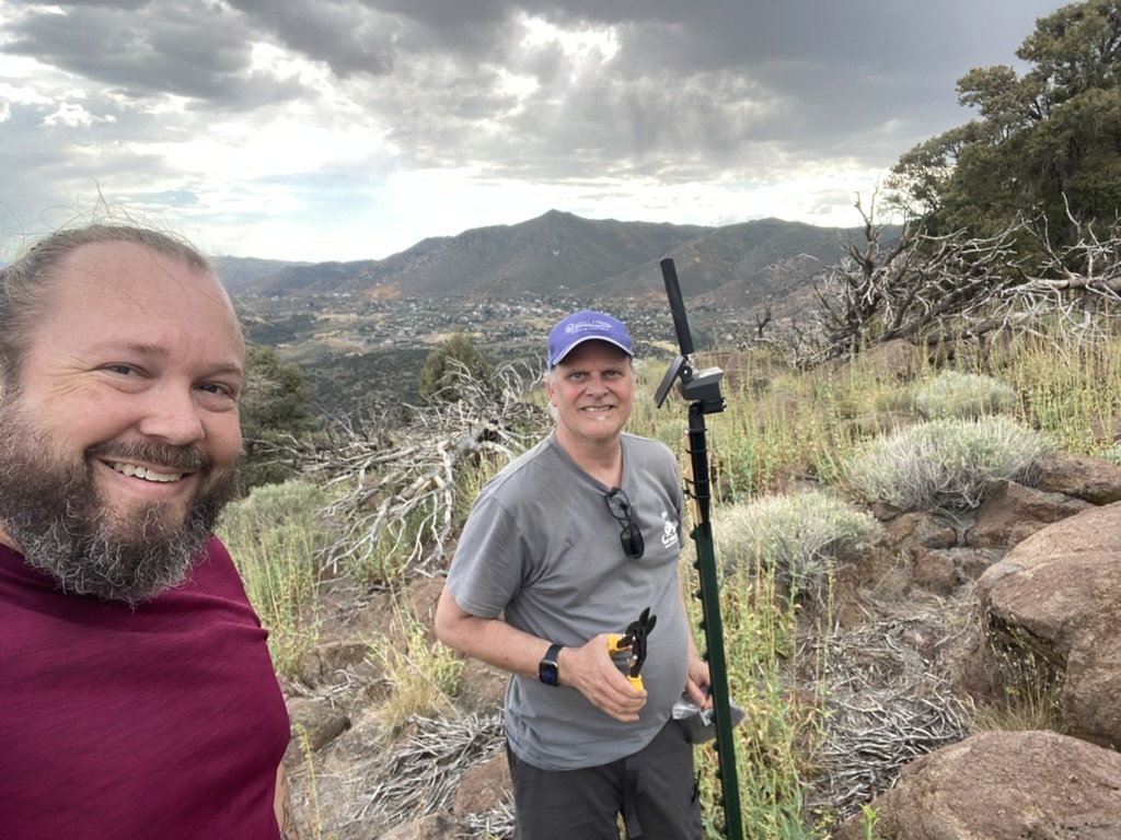 Ben and Tim at the Flowery Peak summit with a T-post mesh node and Virginia City in the valley below