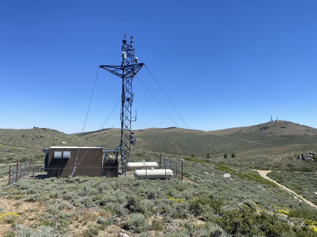 Lattice tower, equipment shelter, and access road at the Sierra Electronics site