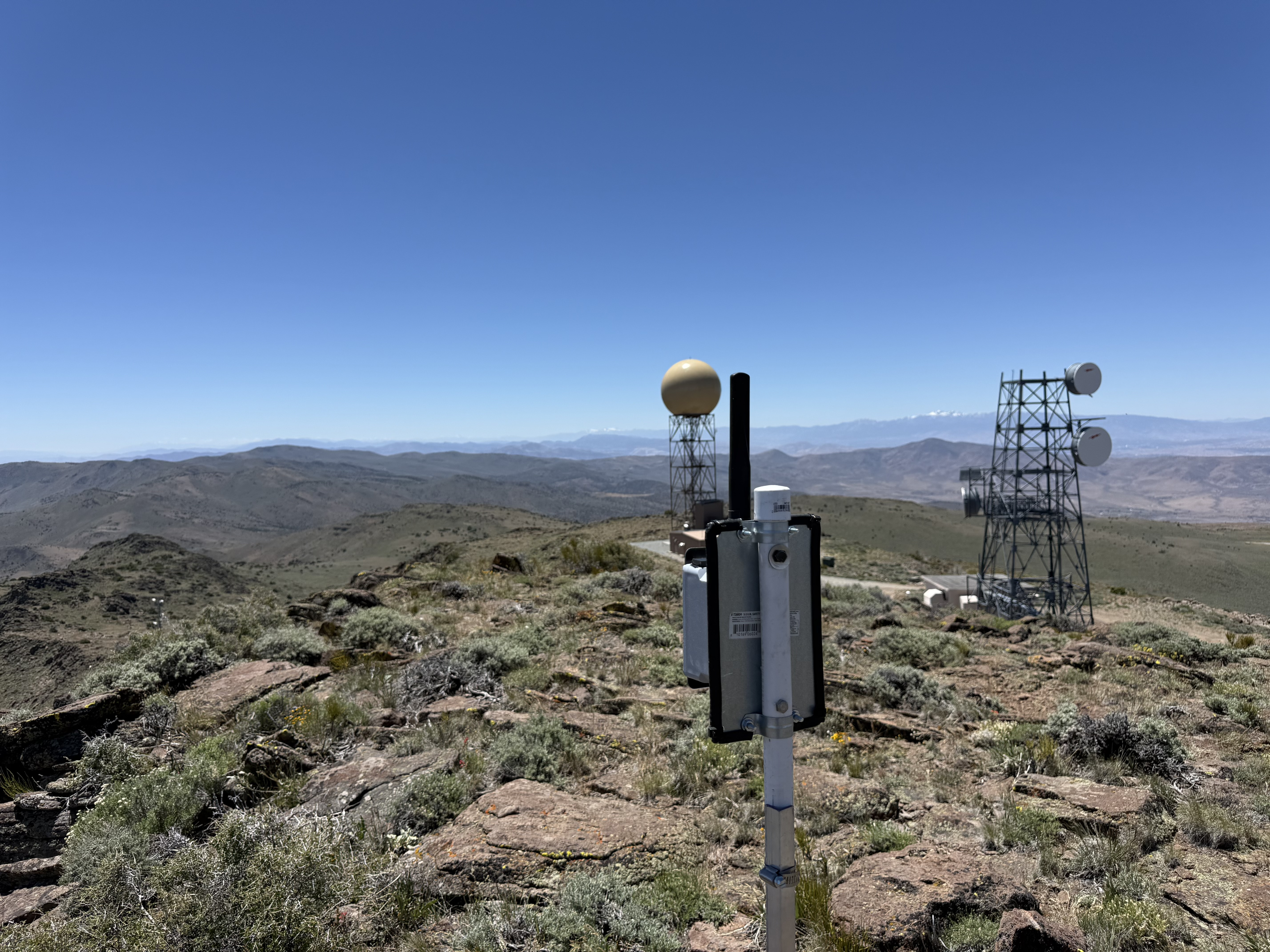 Mesh node on a summit pole with NEXRAD radar and microwave towers on Virginia Peak